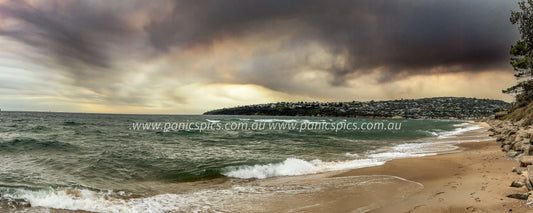 Stormy beach scene with dark clouds and rough waves.